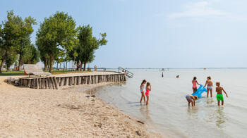 Kinder schwimmen und plantschen im See im Strandbad Neusiedl am See