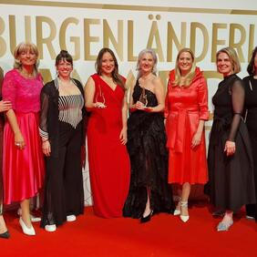 Im Bild: Landtagspräsidentin Astrid Eisenkopf, Bürgermeisterin LAbg. Elisabeth Böhm, Johanna Halbritter, Preisträgerin Lynda Salman Dinhof und Burgenländerin des Jahres 2026 Doris Zoder-Spalek, Landesrätin Daniela Winkler, Geschäftsführerin der Freizeitbetriebe Neusiedl am See GmbH Alexandra Göschl und Amtsleiter Judith Siber-Reiner.