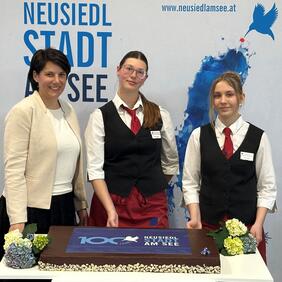 Zwei Schülerinnen vom Pannoneum und Pädagogin Katharina Kaintz mit der Jubiläumstorte.